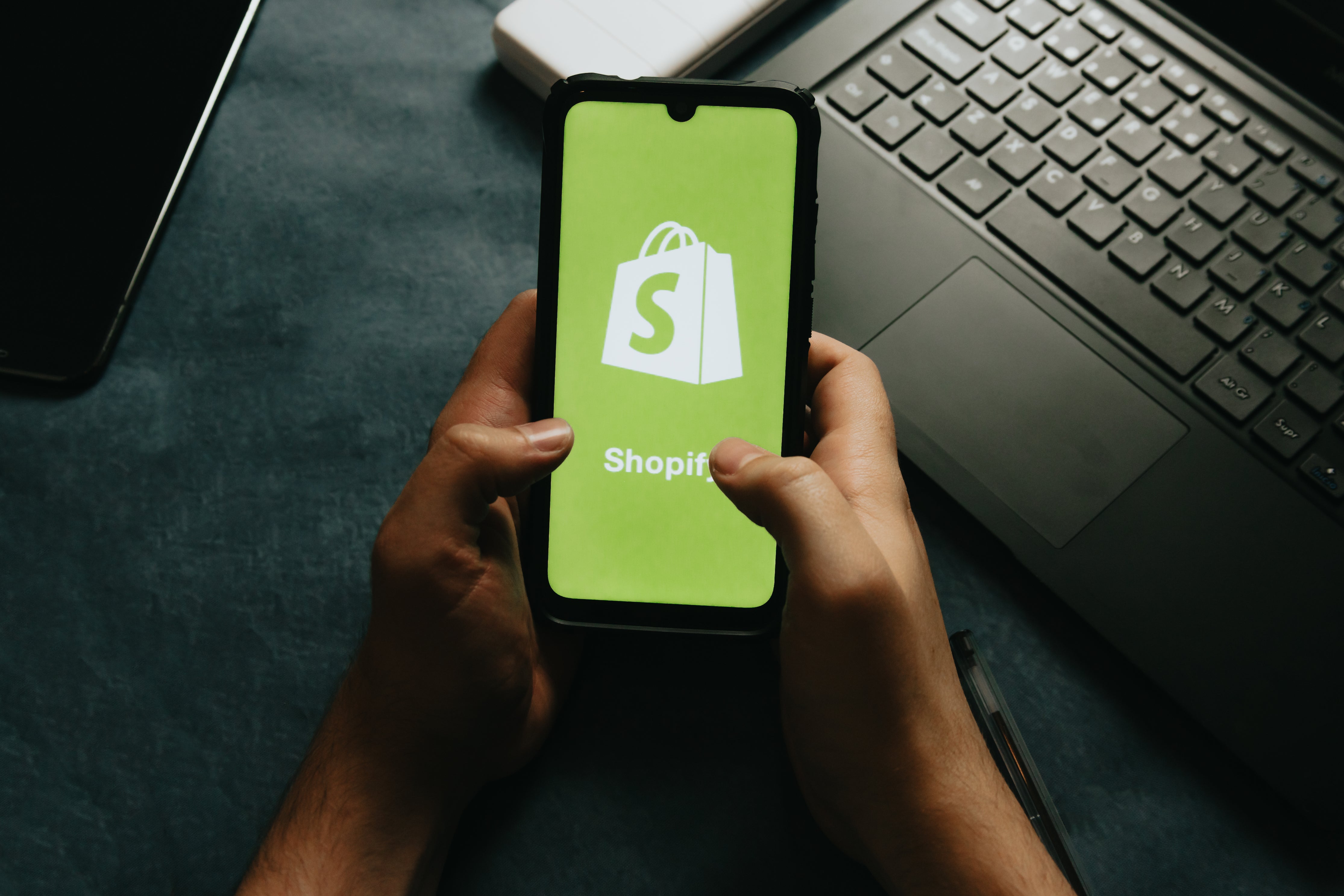 hands holding a phone with an e-commerce logo
